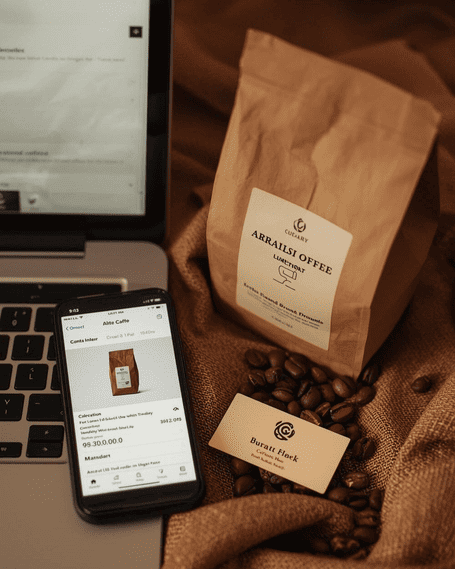 Teléfono mostrando un pedido en línea, con paquete de café y granos