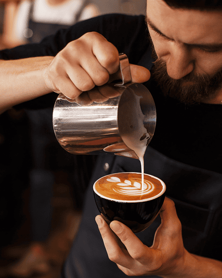 Barista realizando latte art en un café