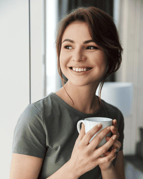 Joven sonriendo con una taza de café